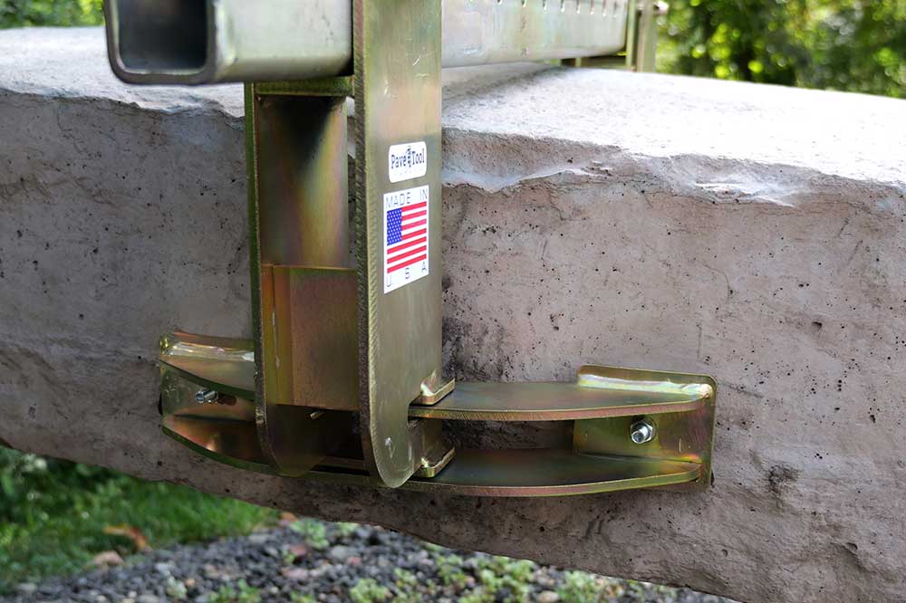 Metal strap hitch attached to a concrete surface with a visible brand label.