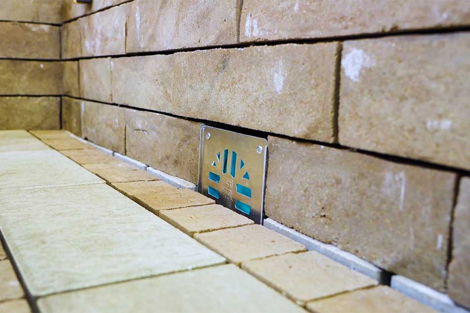 Close-up of a tiled floor with a brand logo on a wall.