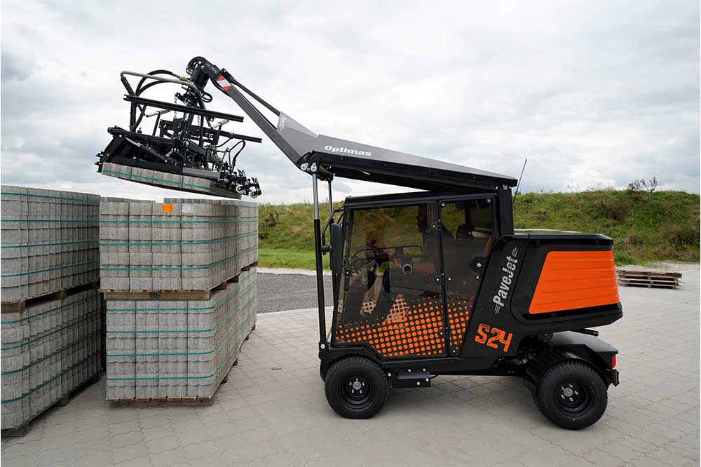 An orange and black S24 PaveJet paver laying machine laying pavers