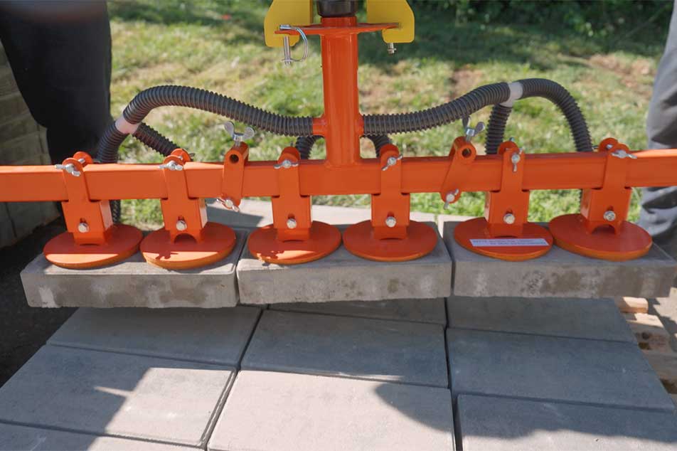 Orange bricklaying tool on a concrete surface with grass in the background